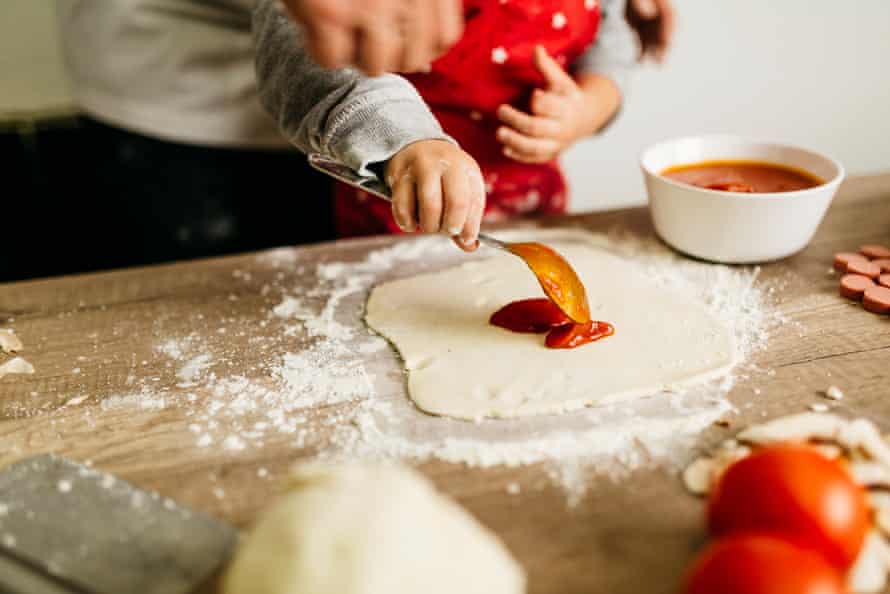 Father and son preparing pizza together.