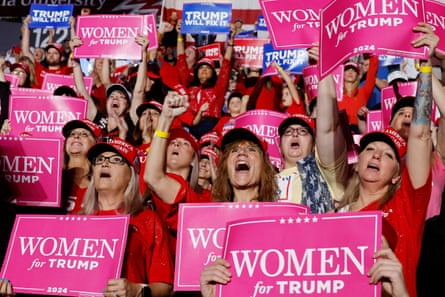 A sea of white women hold pink signs that say ‘Women for Trump’