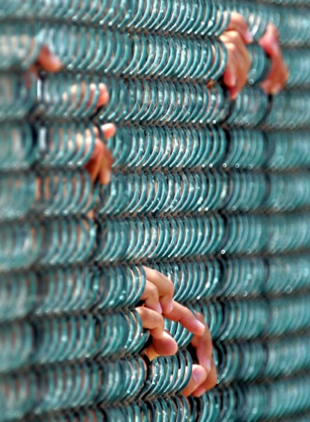 Detainees hold on to a fence at maximum security prison Camp Delta at Guantánamo naval base in August 2004.