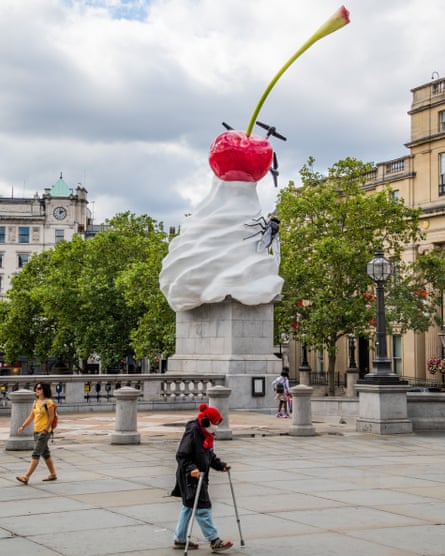 giant dollop of whipped cream, cherry and fly on a plinth in a public square