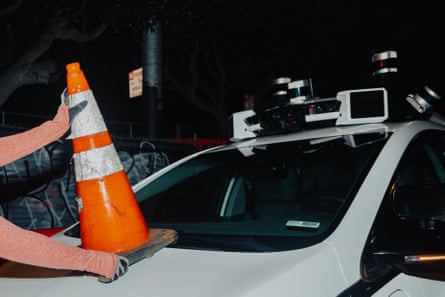 The cone is gently placed, and the car is now disabled, flashers on, inert on the San Francisco street