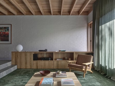 An interior of a mid-century style home with timber ceiling and green curtains