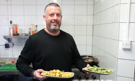 Jim Anderson holding plates of vegan food