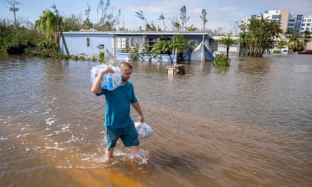A man wades through a flooded neighborhood in the aftermath of Hurricane Ian in Fort Myers last September.