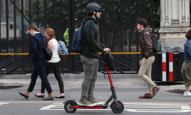 A man riding an electric scooter in Westminster, London. 