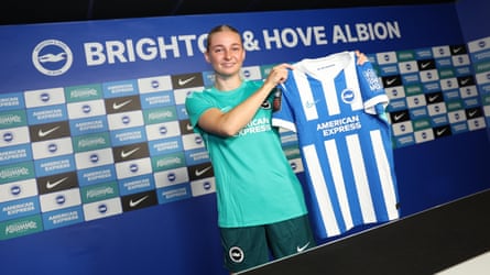 Emilie Joramo holds up a Brighton playing shirt while wearing their training kit during her presentation after signing for the club.