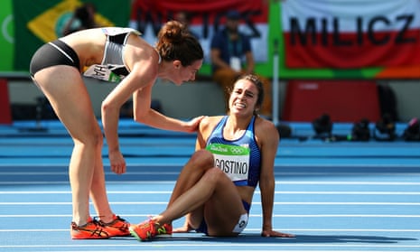 Abbey D’Agostino of the United States (R) is assisted by Nikki Hamblin of New Zealand after a collision during the Women’s 5000m heat.