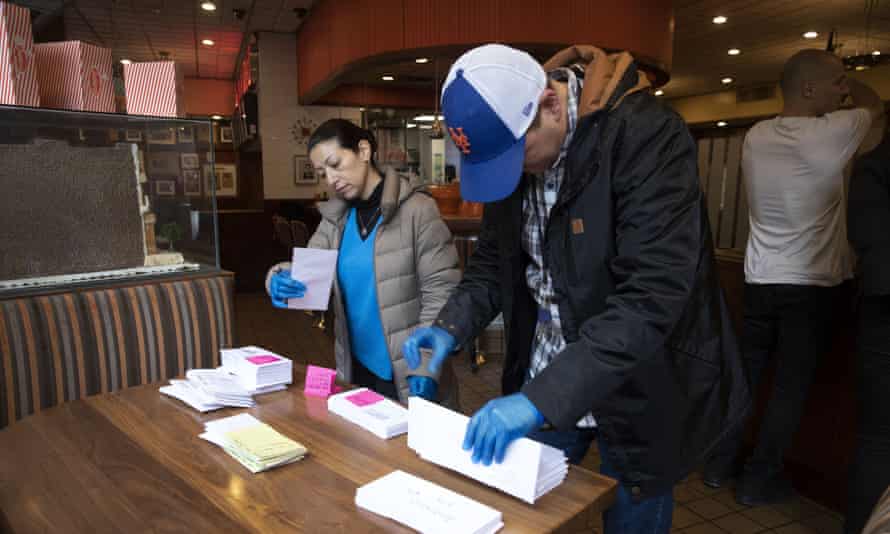 Employees of Junior’s Restaurant in Brooklyn sort paychecks for fellow workers who are picking them up.
