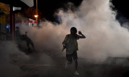 A protester runs after police fired teargas