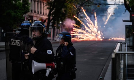 Police stand guard during clashes in Lyon.