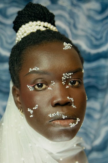 A bride with pearl-decorated hair and pearl clusters across her face