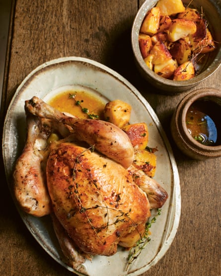 Roast chicken with roast potatoes and roasting juices.
