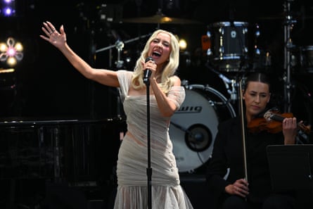 Woman in white dress sings.