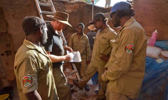 Lead researcher Prof Chris Clarkson, second from left, standing in front of the 2015 excavation area with local Djurrubu Aboriginal Rangers Vernon Hardy, left, Mitchum Nango, centre, Jacob Baird, second from right, and Claude Hardy, right, at Madjedbebe, a rock shelter in Kakadu that was inhabited 65,000 years ago