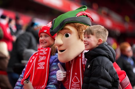 A couple of young fans pose for a photo with Nottingham Forest mascot Robin Hood.