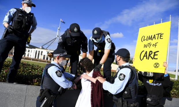 An Extinction Rebellion activist is removed by police officers during a climate crisis protest outside Parliament House in Canberra, Australia in October 2021.