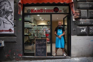Sasi, a hairdresser, wearing an azzurro apron at his salon in Vico Due Porte a Toledo. The apron is styled on the historical Napoli jersey from the 1987-88 season, probably the most iconic ever, honoured by the double tricolour cockades of Scudetto and Coppa Italia won the year before.
