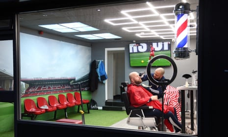 A man gives a shave at a barber shop ahead of the English Premier League football match between Nottingham Forest and Manchester United
