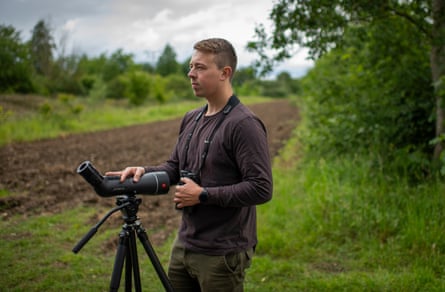 Harry Read stands in a field with a spotting scope