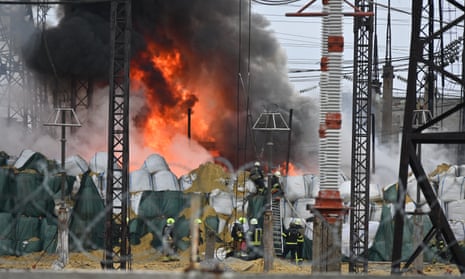Firefighters extinguish a blaze at an electrical substation after a missile attack in Kharkiv.