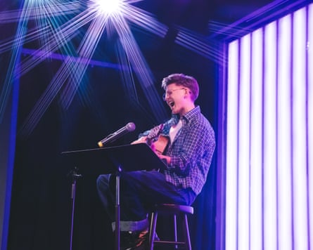 a person plays the guitar on stage