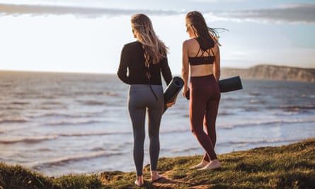 Femmes sur la plage avec des tapis de yoga