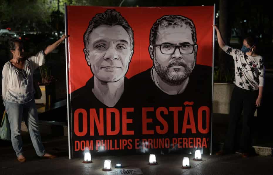 Protestors hold up illustrations of Dom Phillips, left, and Bruno Pereira, days before their bodies were found in the Amazon