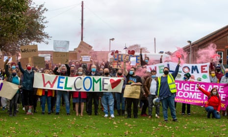 Local residents and community groups holding a sign reading 'Welcome' outside Napier Barracks Folkestone, October 2020.