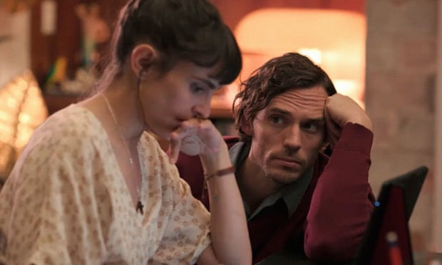 A still from Book of Love shows Verónica Echegui's Maria with a pensive expression, looking downwards with her lower face resting on the back of her hand.  Sam Claflin's Henry is facing the camera, looking at her with raised eyebrows and a furrowed brow.