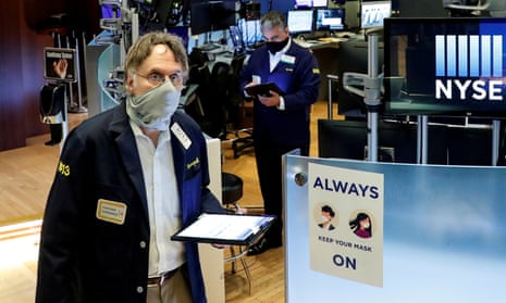 Traders wearing masks work on the floor at the New York Stock Exchange (NYSE) in New York