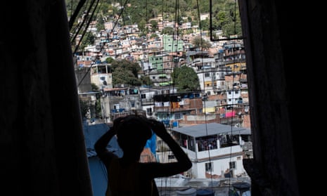 A boy walks through the Rocinha favela in Rio de Janeiro on 13 August 2016, where residents are still waiting for infrastructure promised under a federal investment programme.