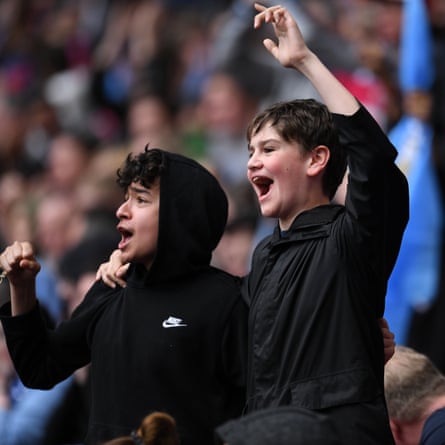 Two Chelsea fans sitting in the Manchester City section celebrate after Kerr scores their first goal.