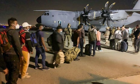 French and Afghan nationals line up to board a French military transport plane at the Kabul airport