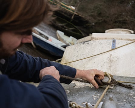 Green’s hands tie a rope around a stanchion.