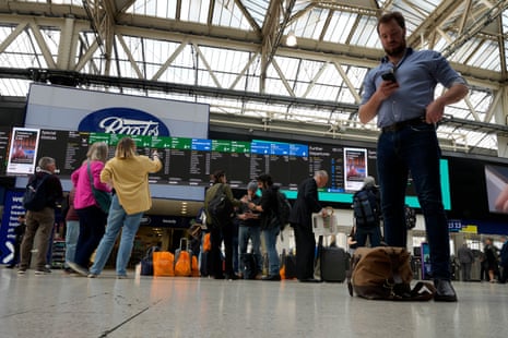 Travellers check the departure board at Waterloo station in London as members of the train drivers’ union Aslef strike during their long-running dispute over pay.