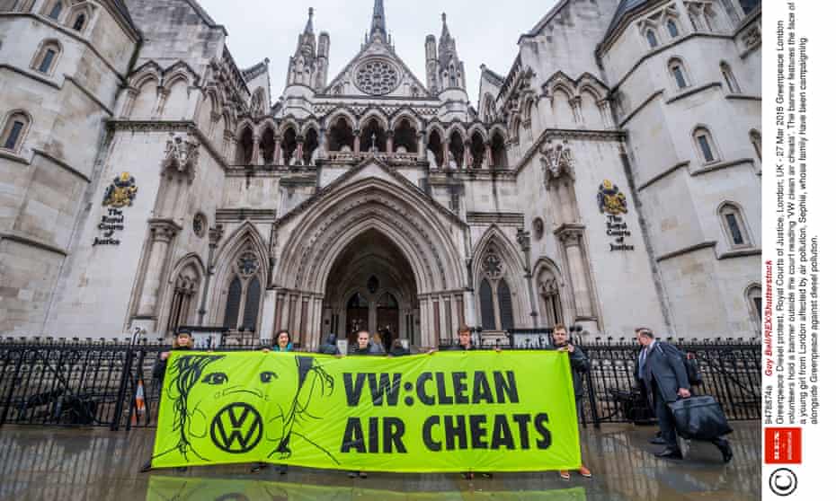 volunteers hold a banner outside the court reading 'VW clean air cheats