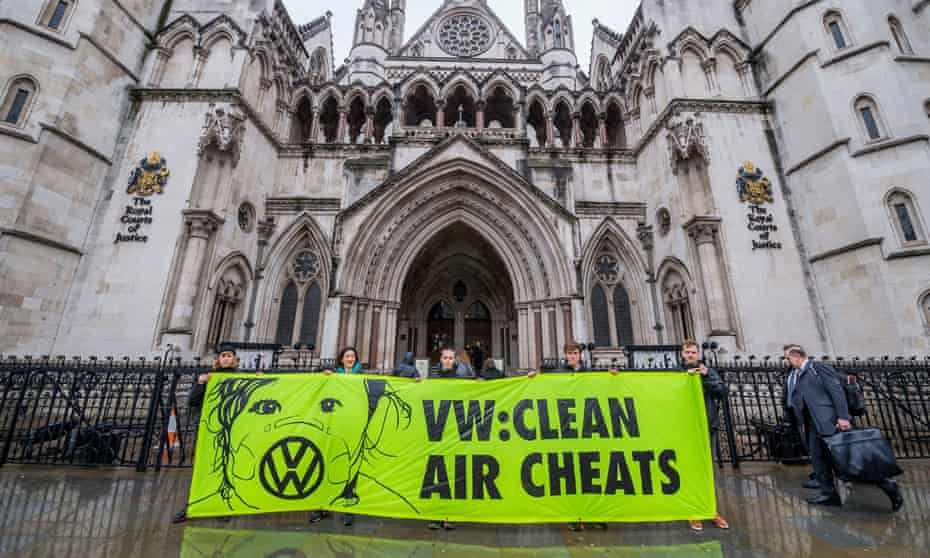 volunteers hold a banner outside the court reading 'VW clean air cheats