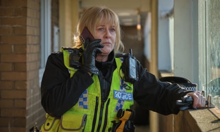 Happy Valley’s ‘good cop’, Catherine Cawood (played by Sarah Lancashire), leans on a windowsill as she makes a call.