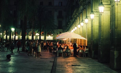 People eating outside at night in Barcelona.