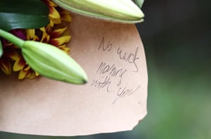A note reading ‘No words, mourning with you’ is seen on bouquet of flowers left by a member of the public.