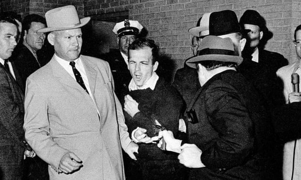Lee Harvey Oswald, suspected assassin of President Kennedy, grimaces as he is shot to death at point-blank range by nightclub owner Jack Ruby in the basement of the Dallas police headquarters on 24 November 1963.