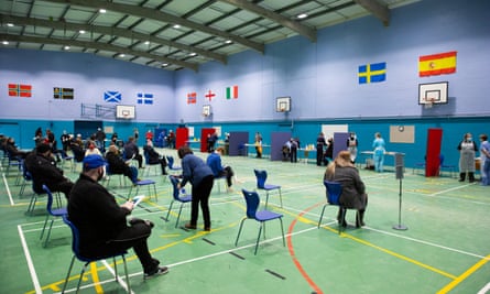 People wait for vaccinations in a school sports hall in Thurso, on the north coast of Scotland.