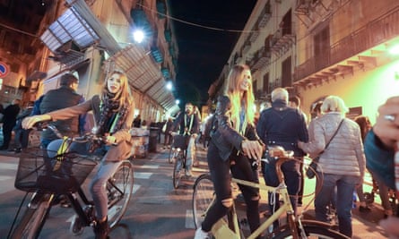 A night view of cyclists riding in Via Maqueda in Palermo