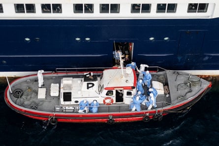 A small boat docked alongside the Hondius with medics in protective gear on the deck