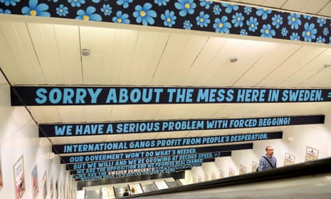 A man ascends an escalator as signs put up by the Sweden Democrats political party are seen at Ostermalmstorg subway station in Stockholm<br>