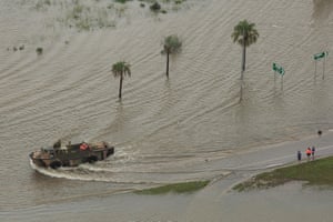 An army vehicle pushes through flood water. Torrential rain saw unprecedented water releases from the city’s swollen dam