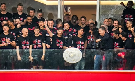Xabi Alonso holds the Bundesliga trophy for supporters on the pitch to see at the BayArena.
