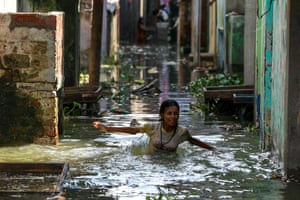 A girl wades through a flooded street
