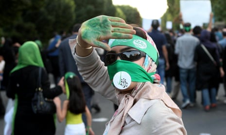 A Green movement supporter covers her face with piece of cloth and a sign in Persian with the name of an opposition leader Mir Hossein Mousavi at a 2009 rally in Tehran.