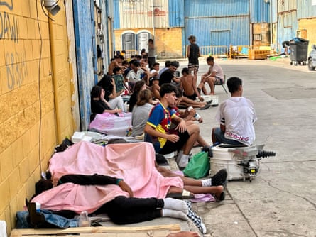 Migrants who entered the Spanish enclave by swimming or on foot from Morocco sit on a street in Ceuta, 3 August 2026.